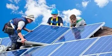 Técnicos instalando paneles solares en techo